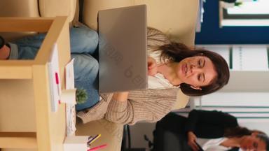 业务女人会说话的视频会议调用移动PC坐着沙发上
